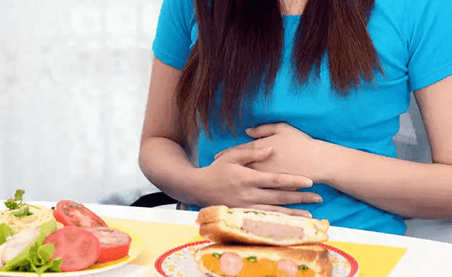 Woman experiencing indigestion after meal
