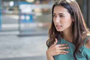 a lady looking uncomfortable with her hand on her chest