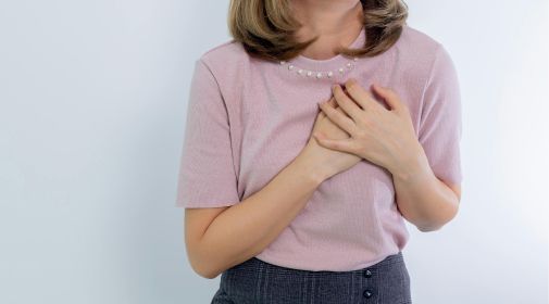 Close-up of woman placing both hands on her chest