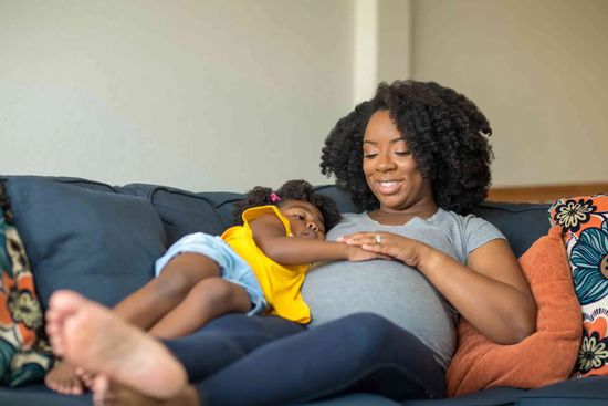 Pregnant Adult Resting With Child