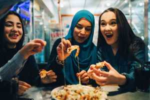 three girls ecstatic while sharing food